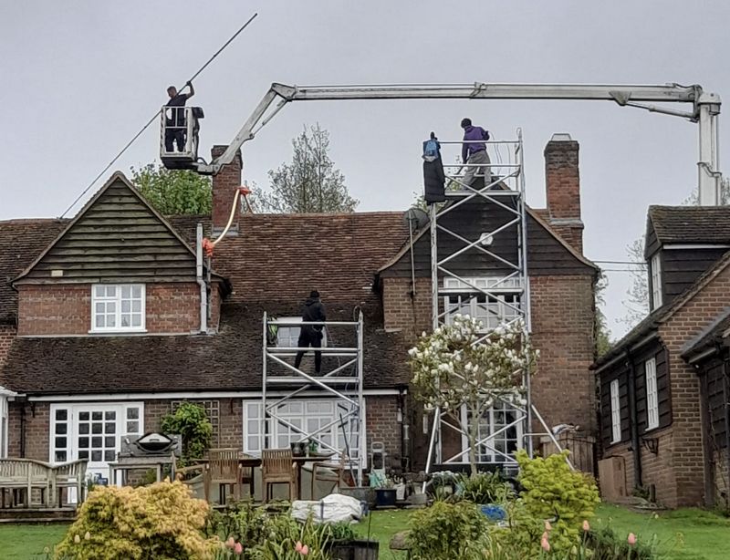 The Moss Cleaners using cherry picker and scaffolding to clean roof safely and professionally in Staines, Surrey